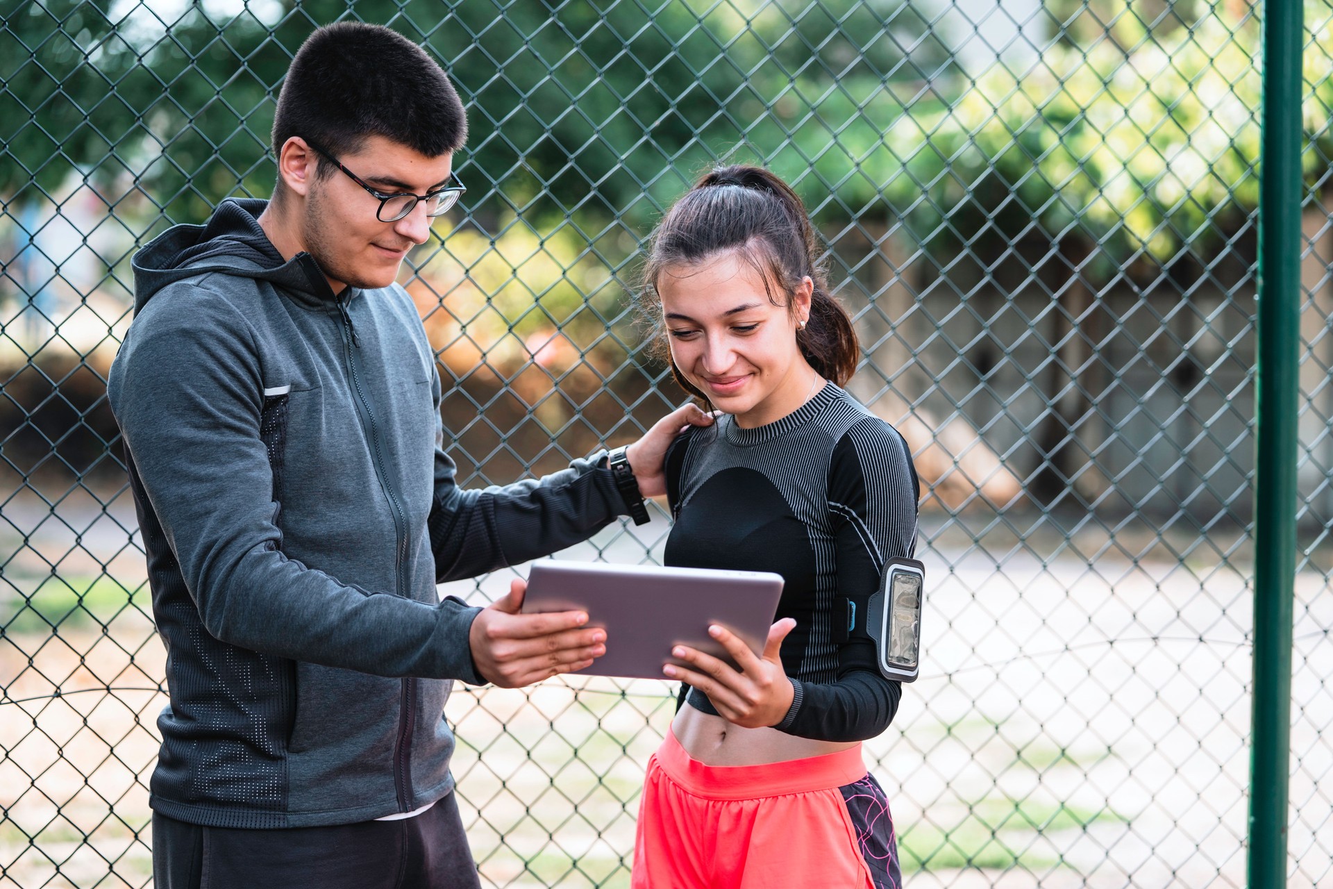 Girl an her coach monitoring her progress on digital tablet.